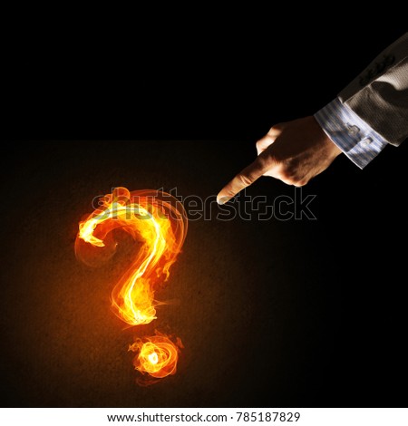 Close of businessman hand showing burning fire sign on dark background