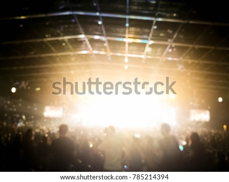 Abstract blurred artist performs songs from stage during concert to be background. Bokeh of lighting in concert with audience