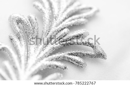 Silver snowflake in macro closeup on a white background. Soft image, christmas and happy new year. High resolution photography.