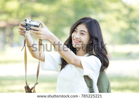 Attractive Asian woman using retro camera for selfie with smiling, Woman using camera at outdoor place.