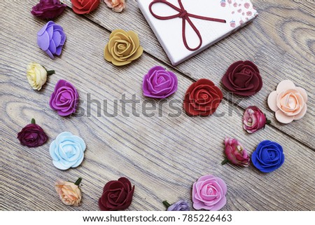 Lovers day concept. Gift box with group of heart shaped roses on wooden table. Top view with copy space