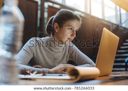 Business woman using laptop in open work space 
