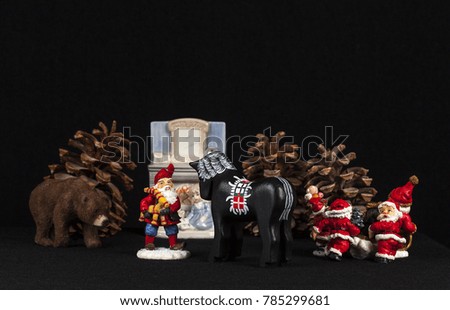 Red and white mini figure collection isolated on black. Christmas decoration, pine cones, fireplace on black background. Closeup
