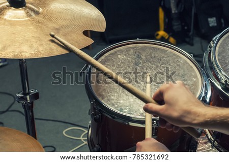Drum sticks, a plate and a drum (volume). Playing on the drum kit drummer. close-up. Selective focus.