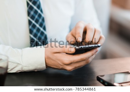 Close-up image of male hands using smartphone at night on city shopping street, searching or social networks concept, hipster man typing an sms message to his friends Royalty-Free Stock Photo #785344861