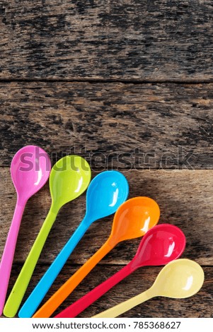 Colorful plastic spoons on wooden background,copy space