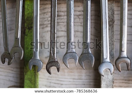 Old hand tools hanging on wall in workshop or auto service garage, many tool shelf against a wall, repair and car mechanic concept.