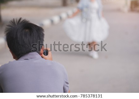wedding photographer in action, wedding photographer takes pictures of the bride and groom in nature. Behind the scene of photography working concept.