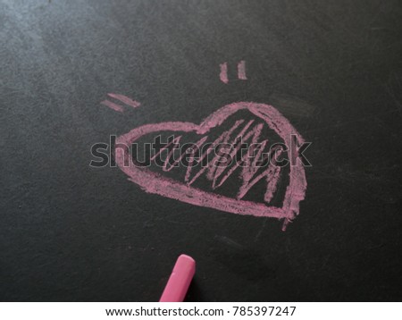 Chalk drawing of pink heart on the blackboard,