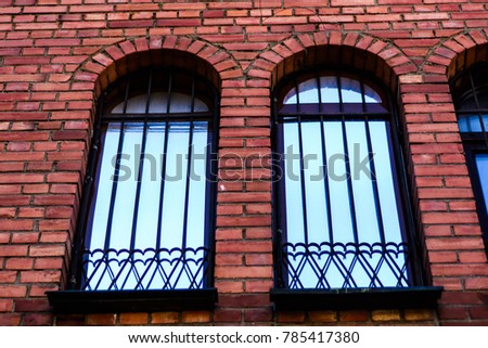 decorative wrought metal fence on the Windows of the Gothic brick house