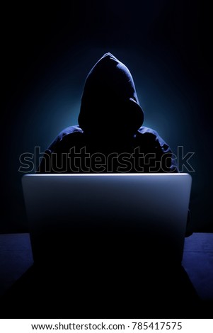 Hacker in front of his computer. Dark face Royalty-Free Stock Photo #785417575
