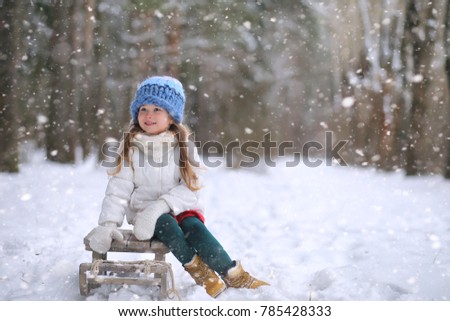 Winter fairy tale, a daughter ride a sled in the forest. A girl on a sled with gifts on the eve of the new year in the park. New Year's park and ride a sled with gifts.