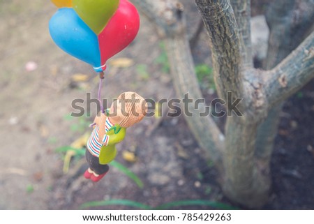 colorful doll hanging on tree branch with vintage colorful picture style