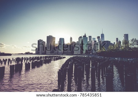 Wooden logs in East river and Manhattan with sunset in vintage style