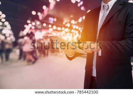 businessman using tablet with blurred event background
