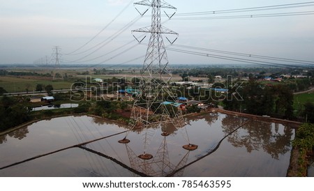 Aerial view of Rice farm with Water Surface and Electricity Tower on morning time,Aerial view countryside in Thailand background.