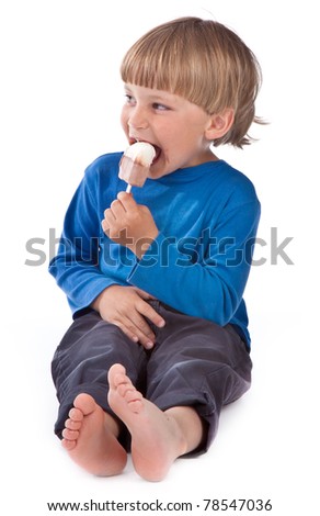 small boy eating ice lolly on white background