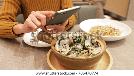 Woman taking photo on bowl in restaurant