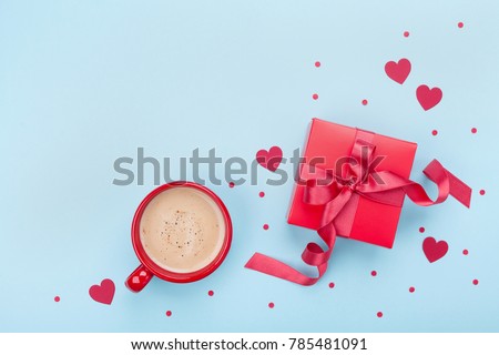 Breakfast for Valentines day. Coffee, gift box, paper heart and confetti on blue background top view. Empty space for text. Flat lay.