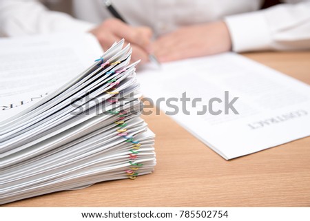 A pile of documents with the man in the document