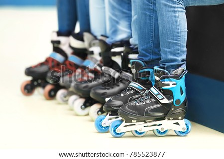 Group of people wearing roller skates on light background