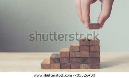 Hand arranging wood block stacking as step stair. Ladder career path concept for business growth success process, Copy space Royalty-Free Stock Photo #785526430