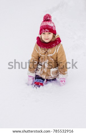 A child in the winter in the snow. To make a snowman. Selective focus.