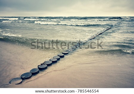 Retro toned picture of an old wooden beach breakwater, peaceful natural background.
