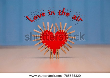 "Love in the air" card with red paper heart on table with blue wooden background