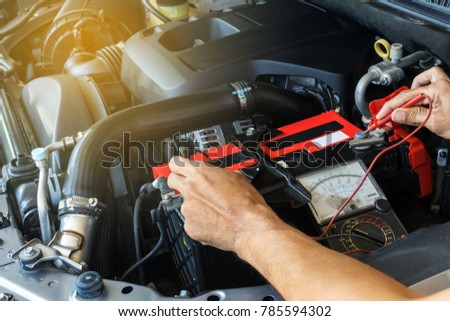 Mechanic car service using Multimeter to check the voltage level in a car battery Royalty-Free Stock Photo #785594302