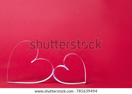 St. Valentine's day concept: two paper hearts on red background. close up view.