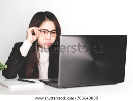 Asian business woman wearing black suit and glasses on work desk, She intends to work fully and be happy with it.