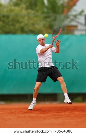 Tennisplayer hitting hard topspin forehand Royalty-Free Stock Photo #78564388