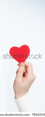 Female hand holding red paper heart