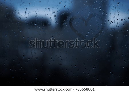Heart on the rainy window background