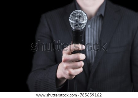 Close up of a man wearing suit holding microphone - public speaking, conference, reportage