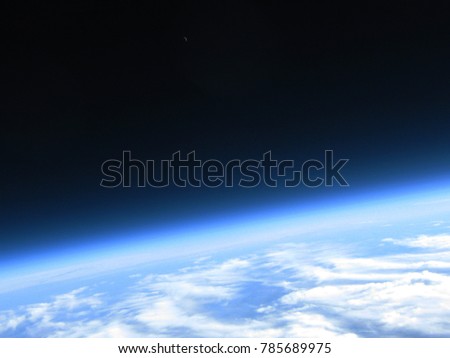 Curvature of the earth and crescent moon in single shot taken from a high altitude balloon flight to the stratosphere Royalty-Free Stock Photo #785689975
