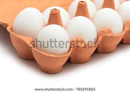 White chicken eggs in a cardboard container for storage and transportation isolated on white background
