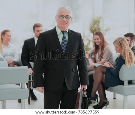 Portrait of happy businessman with  colleagues interacting on ba