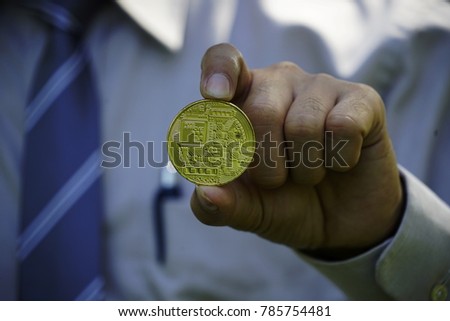 Biz Coin ,Cryptocurrency golden bitcoin coin. Man holding in hand symbol of crypto currency - electronic virtual money for web banking and international network payment, selective focus, toned.