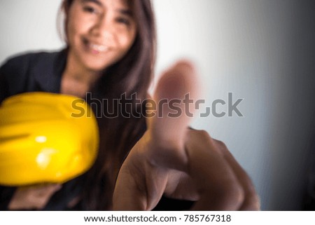 Blurry portrait of female construction worker  holding yellow helmet,Selective focus