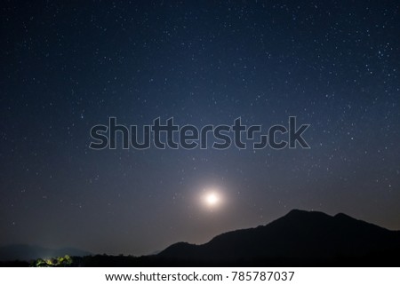 Mountains, moon and stars shine in the beautiful sky after sunset.