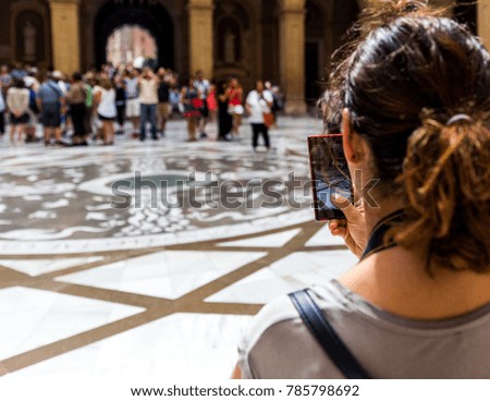 A female tourist takes a photo on her smartphone