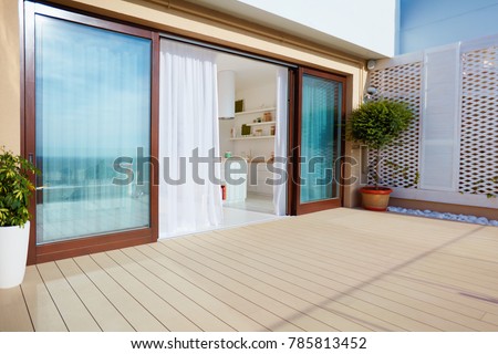 roof top patio with open space kitchen, sliding doors and decking on upper floor
