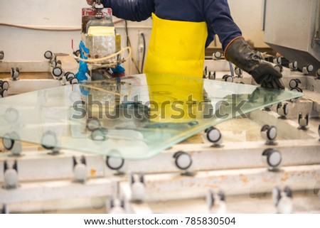 Tempered glass factory worker is working on tempered glass. Glazier is working with tempered glass