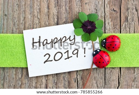 New Year card with leafed clover and ladybugs on wooden background