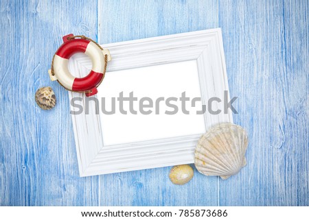 Maritime background with lifebuoy and sea shells, copy space in centered white picture frame, on weathered blue wood