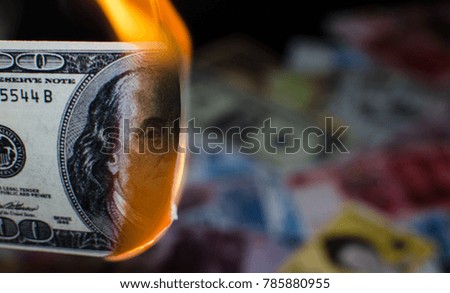 A hundred dollar bill in American US currency is on fire