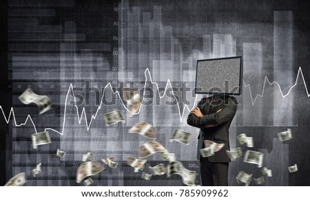 Businessman in suit with TV instead of head keeping arms crossed while standing against flying dollars and analytical charts drawn on wall on background.