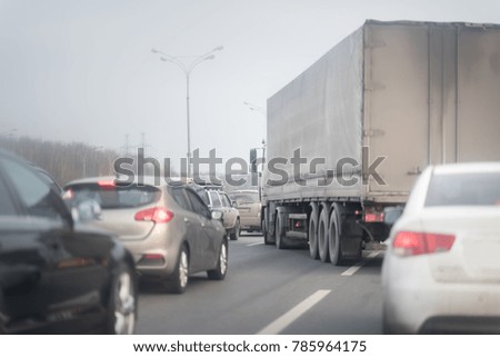 truck driving on the asphalt road. Traffic jam with a lot of cars. Winter time.